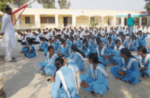 Indian students standing together during a school morning assembly while listening to a thought of the day in Hindi and English